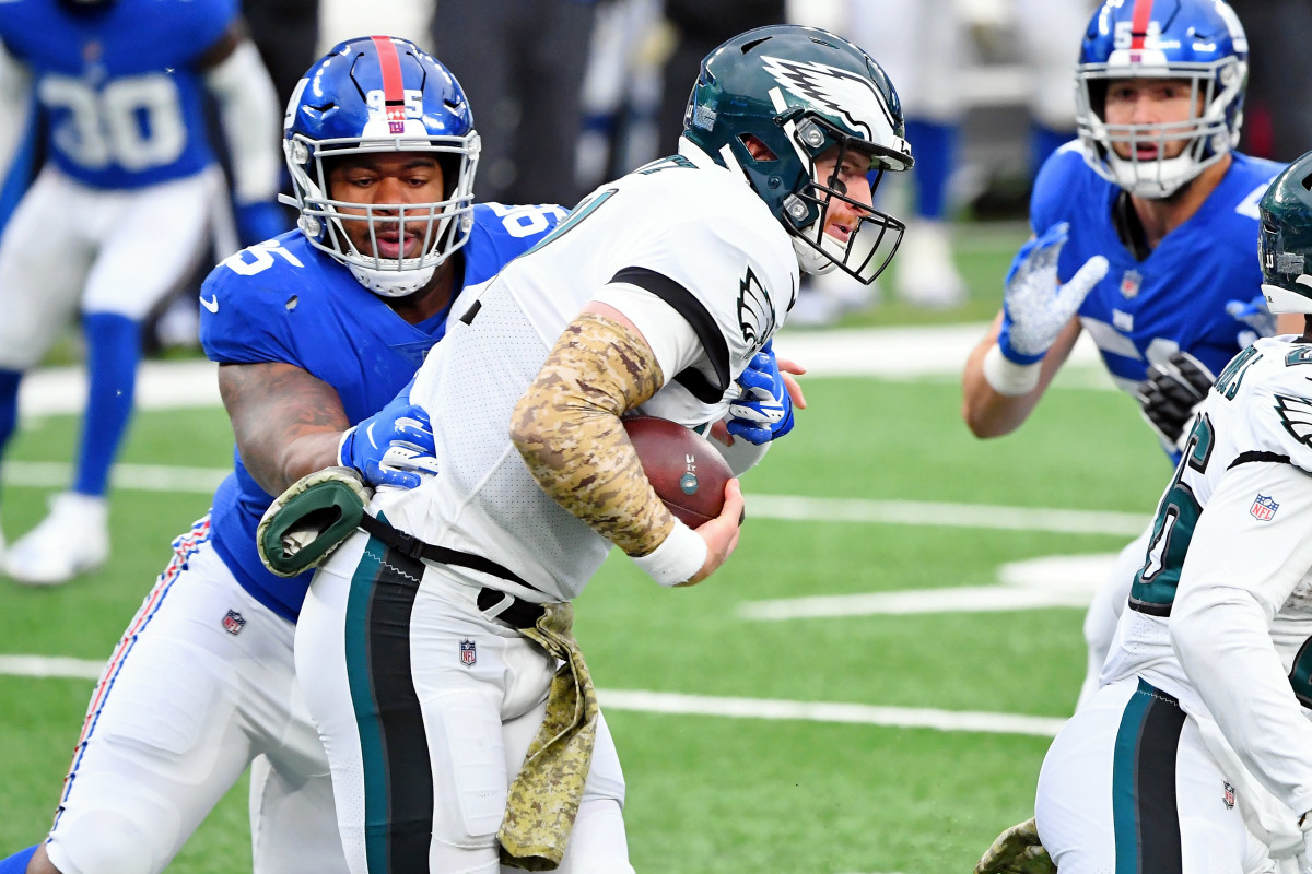 Nov 15, 2020; East Rutherford, New Jersey, USA; New York Giants defensive tackle B.J. Hill (95) tackles Philadelphia Eagles quarterback Carson Wentz (11) for a loss of yards during the first half at MetLife Stadium.